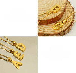 Detail of 18K gold stainless steel letter pendants with tiger texture and mirror polish