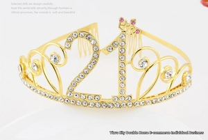 Macro detail of golden 21st birthday crown with white rhinestones and pink accents