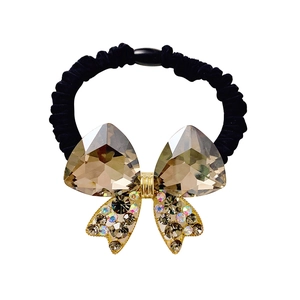 Elastic black hair tie with champagne crystal bow and colorful rhinestones on white background