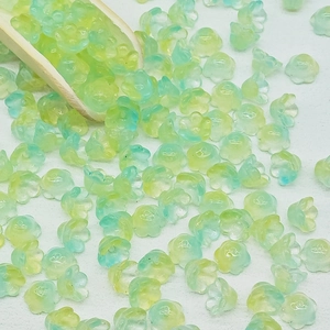 Macro detail of yellow and green gradient lily of the valley glass beads for DIY jewelry