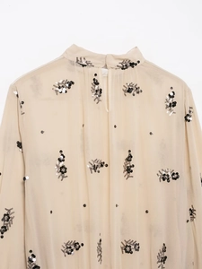 Close-up of beige sheer chiffon blouse with black floral sequins and back keyhole detail