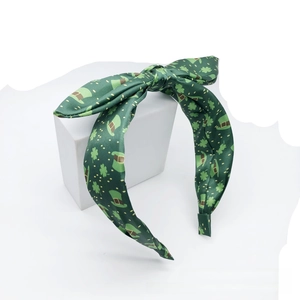 Detail of St. Patrick's Day headband with shamrock prints and a green satin bow