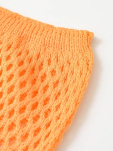 Detailed close-up of vibrant orange hollow-out knitted fabric texture and pattern