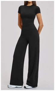 Detail of high-waist wide-leg pants and slim-fit t-shirt in black stretch fabric