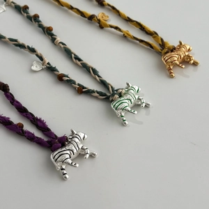 Détail de colliers pendentif zèbre avec cordons colorés et perles en bois