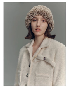 Close-up of the textured brown faux fur knitted hat for women with fluffy winter style