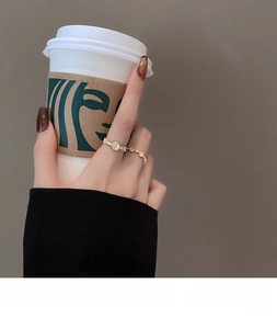 Close-up of gold ring with oval opal and textured band paired with a slim jewelry ring
