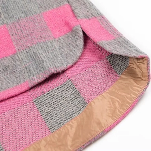 Close-up of pink and grey plaid shirt jacket showing the curved hem and brown lining