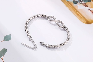 Détail du symbole infini en argent sur un bracelet en maille vénitienne en acier