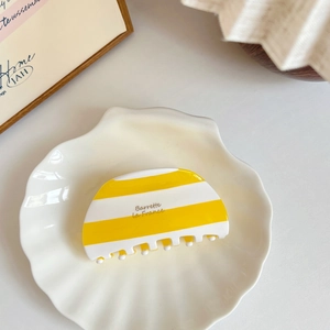French vintage yellow and white striped acetate hair claw clip for a minimalist ponytail