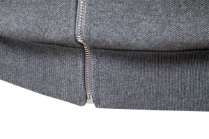 Detailed macro view of the grey knit fabric texture and premium metal zipper closure
