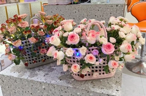 Detail of woven beach baskets in pink and grey with LED lights and colorful roses