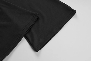 Détail du tissu en maille noire avec ourlet à double couture sur la combinaison