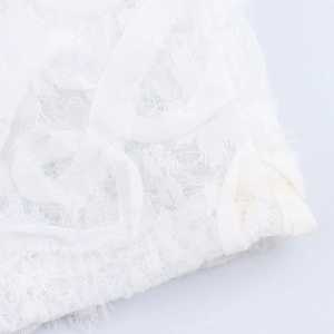 Dettaglio elegante in pizzo floreale 3D bianco di un abito lungo attillato in mesh