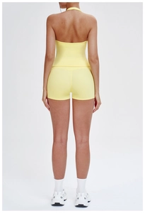 Rear view of yellow brushed yoga set with open back tank top and tight sports shorts
