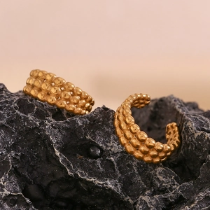 Gros plan des boucles d'oreilles dorées forme C à trois rangées de perles en métal