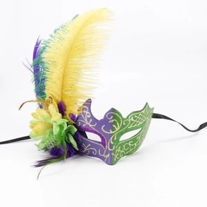 Detail of purple and green feather mask with gold glitter patterns and fabric flowers