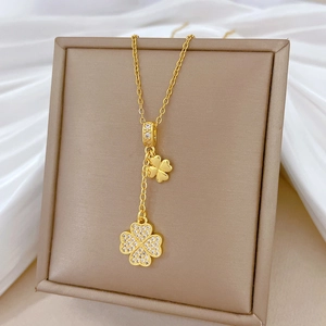 Close-up of golden four-leaf clover pendant necklace with sparkling crystal inlay