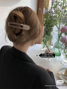Close-up of light coffee duckbill clip styled in an elegant Korean updo hairstyle
