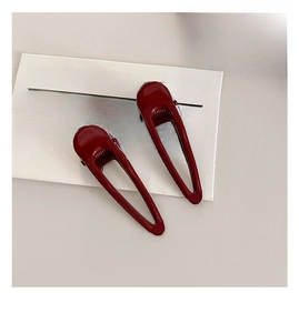 Detailed view of dark red geometric hair clips with spray paint finish and anti-slip teeth