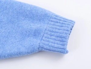 Vista dettagliata dei polsini in maglia a coste azzurro con trama fine ed elasticizzata