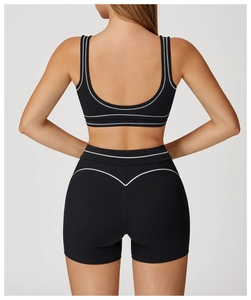 Detail of high-waisted black yoga shorts with white contrast stitching and heart-shaped back seam