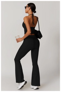 Vue latérale du haut de yoga noir dos nu et du pantalon de sport évasé sur modèle