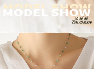 Close-up of model wearing a gold chain necklace with colorful green and blue crystal beads