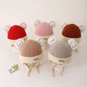 Detailed display of five colorful knit baby hats with bear ears and earflaps