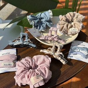 Chic Morandi blue and pink pleated fabric scrunchies and hair clips on a wooden table