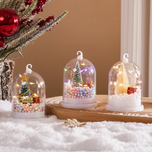Close-up of Christmas glass globe night lights with mini trees and festive LED lighting