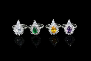 Macro shot of silver bridal rings with pear-cut gemstones in four colors and clear accents