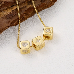 Macro detail of 18K gold plated dice charms with heart, star and letter C zircons