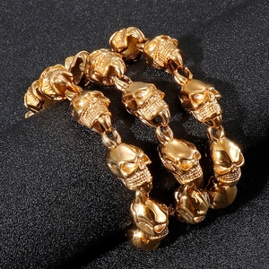 Punk style golden skull link bracelet for men with metallic finish on dark background