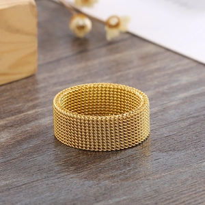 Detail of the golden mesh weave texture on a stainless steel ring over wood
