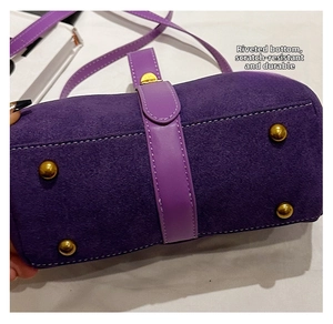 Detail of purple faux suede handbag base featuring four protective gold metal studs