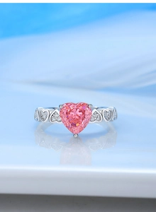 Detailed close-up of pink heart-shaped stone and engraved silver ring with small diamonds