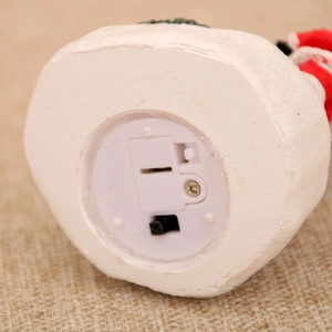 Close-up of resin house base showing the ON/OFF battery switch and burlap background