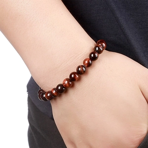 Detailed close-up of a red tiger eye bead bracelet showing natural glossy stone texture