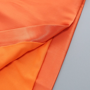 Detailed macro view of orange double-layered fabric with satin finish and mesh knit texture