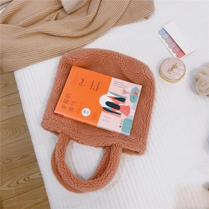 Vista dettagliata della borsa tote in peluche con manici spessi e trama riccia