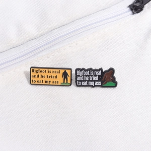 Funny Bigfoot enamel pin set featuring humorous text on white canvas background