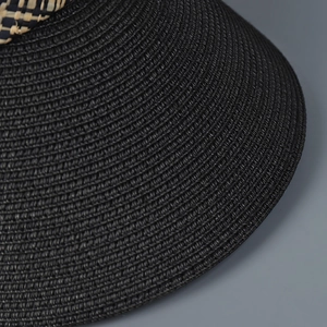 Gros plan détaillé sur la paille tressée noire avec un décor élégant en tissu à carreaux
