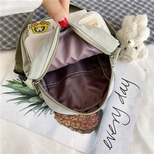 Détail montrant les compartiments internes et la doublure en toile verte du petit sac