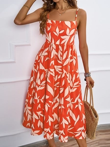 Detail eines eleganten orangefarbenen Sommerkleids mit floralem Print und Stufenrock