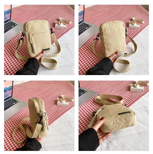 Four-sided view of beige canvas mini crossbody bag with fashion label and zipper details