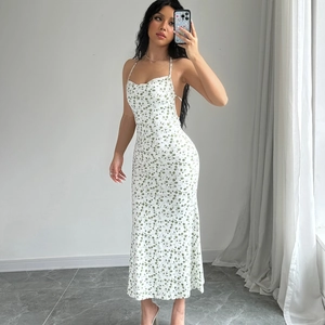 Detail of white midi dress featuring green floral print with backless halter design