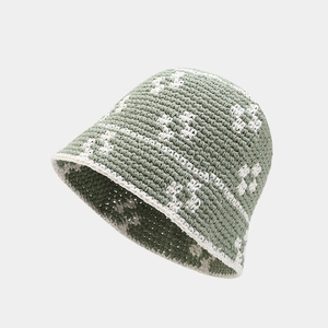 Detail view of the handmade olive green crochet bucket hat with white flower patterns