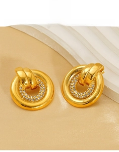 Macro detail of gold-plated titanium steel round earrings with cubic zirconia inlay