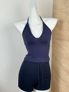 Deep blue halter yoga top and drawstring shorts shown on mannequin against stone wall